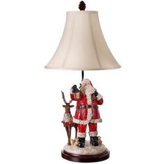 a lamp that has a santa clause on it and a deer standing next to it