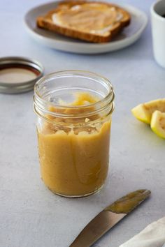 a jar filled with peanut butter next to slices of bread