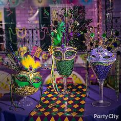 there are three glasses on the table and one is decorated with beads, feathers and other decorations