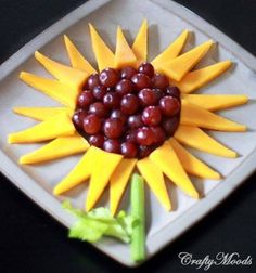 a sunflower made out of fruit is shown in the middle of a card with an image of grapes and cherries on it