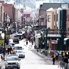 a city street filled with lots of traffic and people walking down the side of it