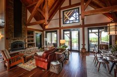 a living room filled with furniture and a fire place next to a wooden floored wall