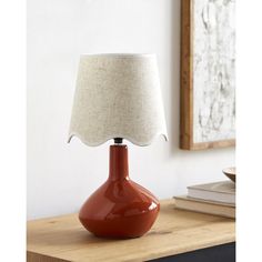 an orange lamp on a table with a white shade