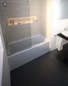 a bathroom with a sink, mirror and bathtub