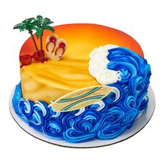 a blue and yellow cake decorated with an image of a surfboard, palm trees and the ocean