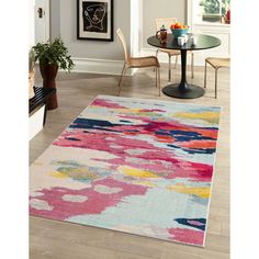 a colorful rug in the middle of a room with a table and chairs next to it