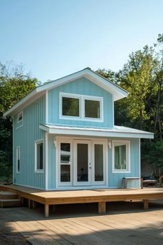 a small blue house sitting on top of a wooden platform