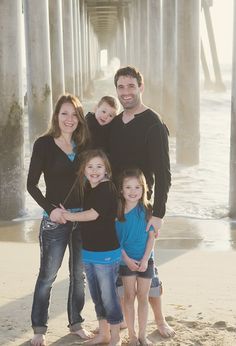 a family poses for a photo under the pier