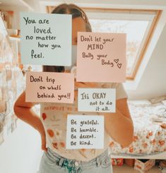 a woman is holding up signs with words written on them that say, you are loved, no matter how you feel