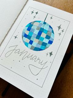 an open notebook with the word january written on it and a blue ball in the middle