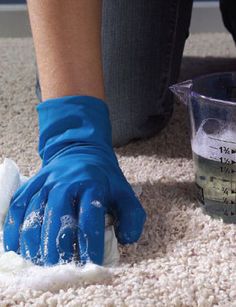 a person in blue gloves cleaning the floor