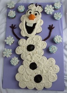 a frosted snowman made out of cupcakes on top of a sheet of paper