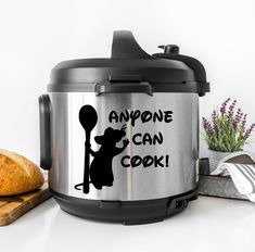 an aluminum crock with the words anyone can cook on it next to some bread