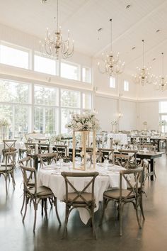 a dining room with tables and chairs set up for a formal function in front of large windows