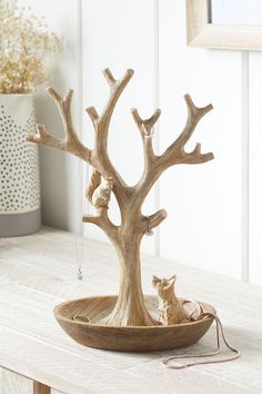 a wooden tree with animals in it on a table