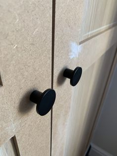 two black knobs on the side of a door