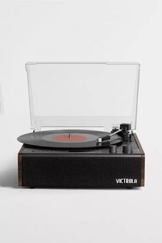 an old record player sitting on top of a wooden stand with clear plastic covering over it