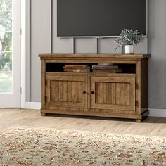 an entertainment center with a flat screen tv mounted on it's wall and a rug in front of it