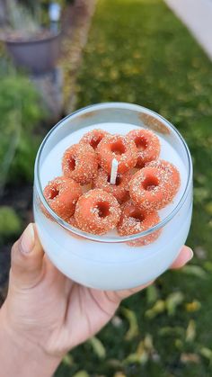 a person holding a glass bowl filled with donuts