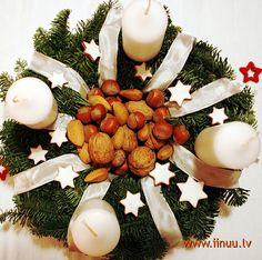 a christmas wreath with candles and nuts in it