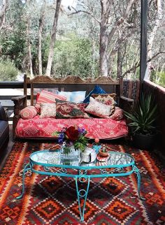 a living room with couches, tables and rugs on the outside patio area