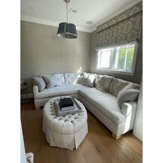 a living room filled with furniture and a large window in the corner next to it