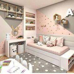 a child's bedroom decorated in pink and grey with polka dots on the walls