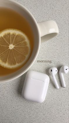 a cup of tea with lemon and ear buds