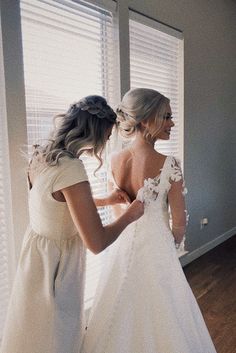 two women in wedding dresses looking at each other