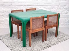 a green table with four chairs and a rug