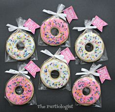 six decorated donuts with pink frosting and sprinkles