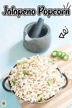 a bowl filled with popcorn sitting on top of a wooden cutting board