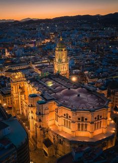 an aerial view of a city at night with the lights on and buildings lit up