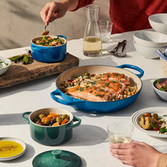 two people are eating at a table with bowls of food and drinks on the table