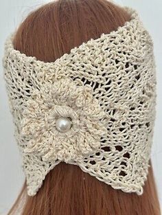 a woman wearing a crocheted headband with pearls on the side and a button in the middle