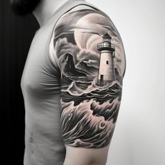 a man's arm with a lighthouse and waves tattoo on his left shoulder, in black and white