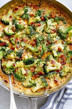 a pan filled with broccoli and cheese on top of a blue and white towel