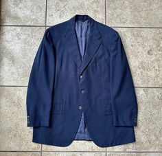 Here is a vintage "Ezon Sportscoat" (actually a blazer) from "Saks Fifth Ave," that can be dated to the 1970s. It is tagged a size 44 Long, but the sleeves were definitely shortened at some point; still, please use the measurements provided to ensure a proper fit. Union-made in the USA of what is assuredly crepe wool, its color is a staple navy blue. The construction is superb, with full canvassing and full lining, and it further features great details, like: a 3-button darted front, flapped patch hip pockets, dual rear vents, brass buttons, and 3-button cuffs. CONDITION: Excellent vintage condition, with the only flaw being some wear to the buttons. MEASUREMENTS: -Pit to pit: 22.75"  -Shoulder seam to shoulder seam (across back): 19.25"  -Sleeve length from top of shoulder: 24.5" plus ~1. Premium Navy Double-breasted Blazer, Mens Sport Coat, Ivy League, Union Made, Blue Paisley, Blazers For Men, Wool Blazer, Online Retail, Sport Coat