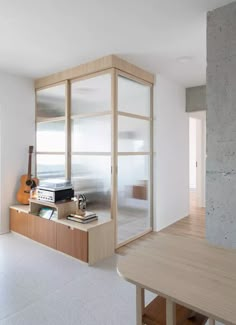 an empty room with a guitar on the table