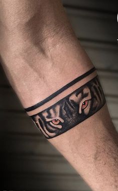 a man's arm with a tiger tattoo on the side of his arm and an eye in the middle