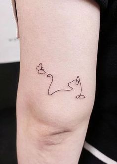 a woman's arm with a small cat tattoo on the left side of her body