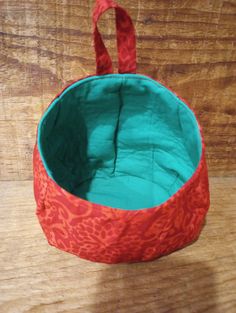 an orange and green bag sitting on top of a wooden table