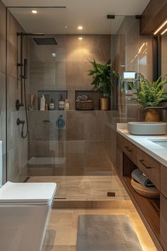 a bathroom with a sink, toilet and bathtub next to a shower stall filled with plants