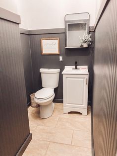 a white toilet sitting next to a sink in a bathroom