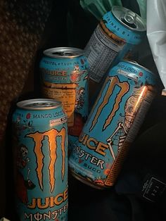 several cans of monster juice sitting on top of a table