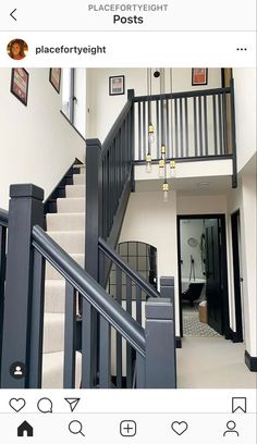 the stairs are black and white in this house with pictures on the wall above them