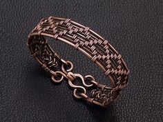 a close up of a metal bracelet on a black surface