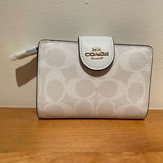 This Coach Medium Corner Zip Wallet In Signature Canvas Is Brand New With Tags. It Originally Retails For $198! The Wallet Is Made Of Signature Coated Canvas And Smooth Leather, Has Seven Credit Card Slots, A Bill Compartment, Id Window, Snap Closure And A Zip Coin Pocket. It Measures 5" (L) X 3 1/2" (H) X 1/2" (W) And The Style Number Is C0082. White Travel Coin Purse With Zipper, White Rectangular Coin Purse With Zipper Closure, White Rectangular Coin Purse With Zipper, White Rectangular Coin Purse, Modern White Leather Wallet, Modern White Bifold Wallet, White Coin Purse With Removable Pouch, White Coin Purse With Removable Pouch For Everyday Use, White Rectangular Coin Purse For Daily Use