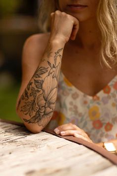 a woman sitting at a table with her hand on her chin