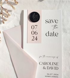 save the date cards and envelopes are laying on top of each other with a wax seal